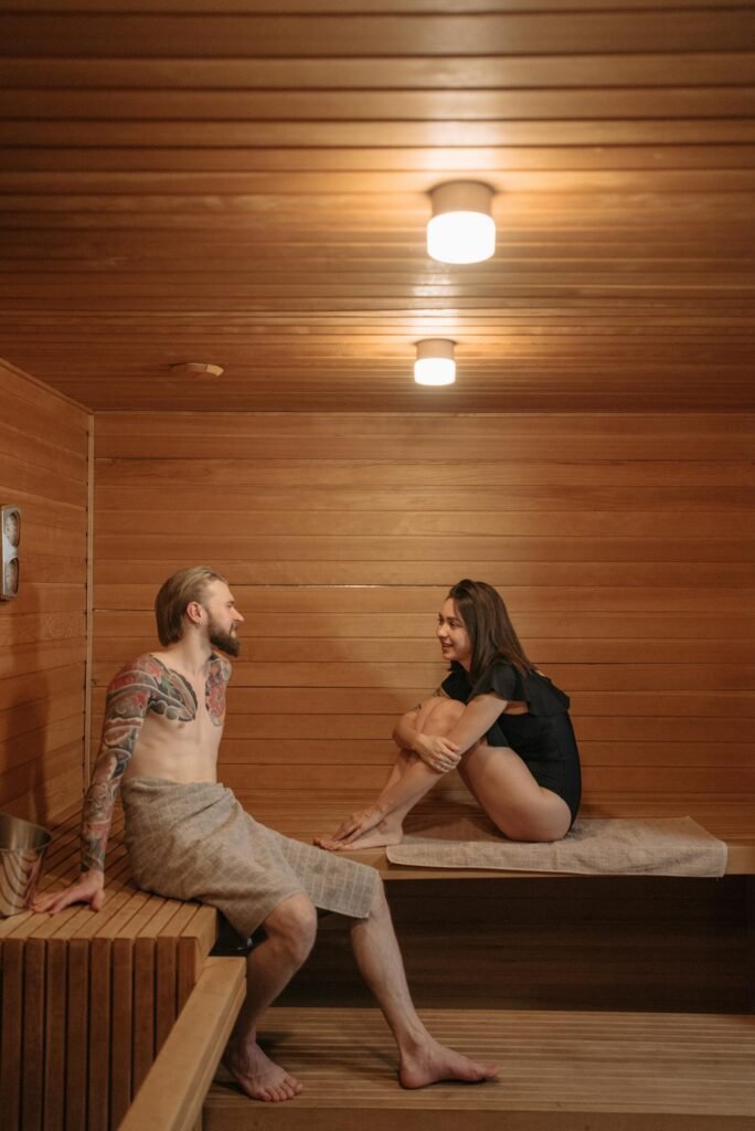 Couple Sitting on a Bench Inside the Sauna